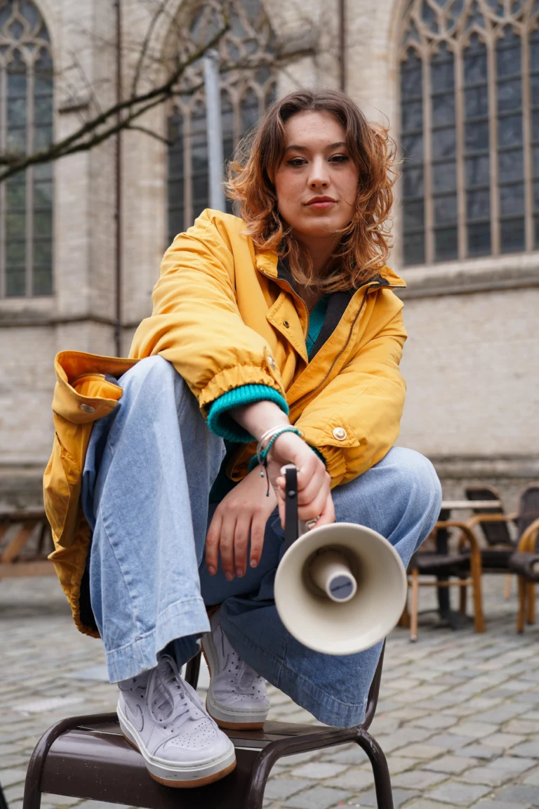 Jasja Renne voor de grote kerk van Breda met een megafoon.